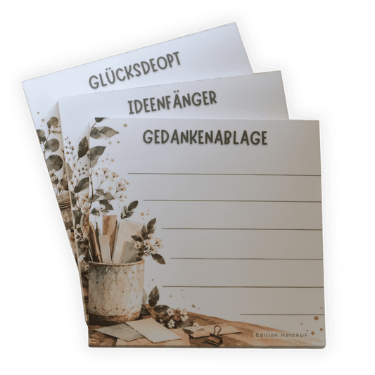 Drei Notizblöcke fächerförmig: GEDANKENABLAGAGE, IDEENFÄNGER und GLÜCKSDEOPT